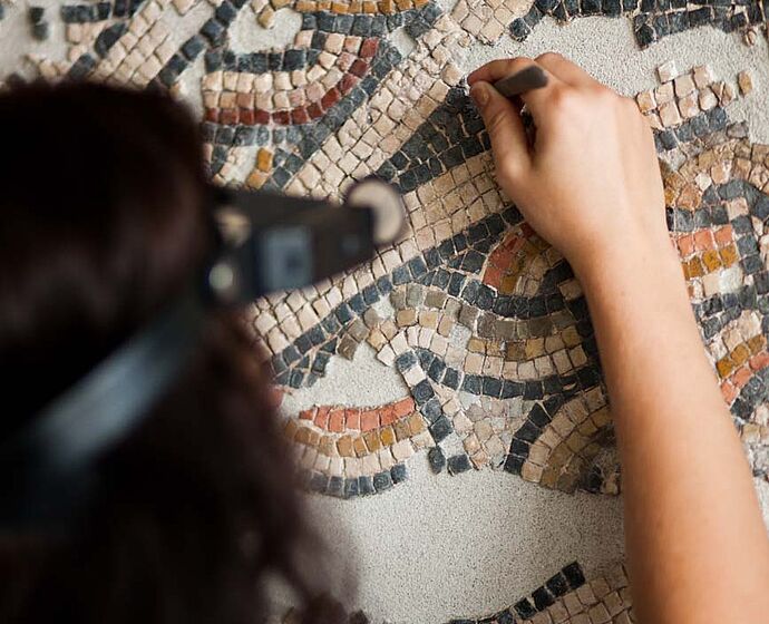 Studentin restauriert am Rennfahrermosaik