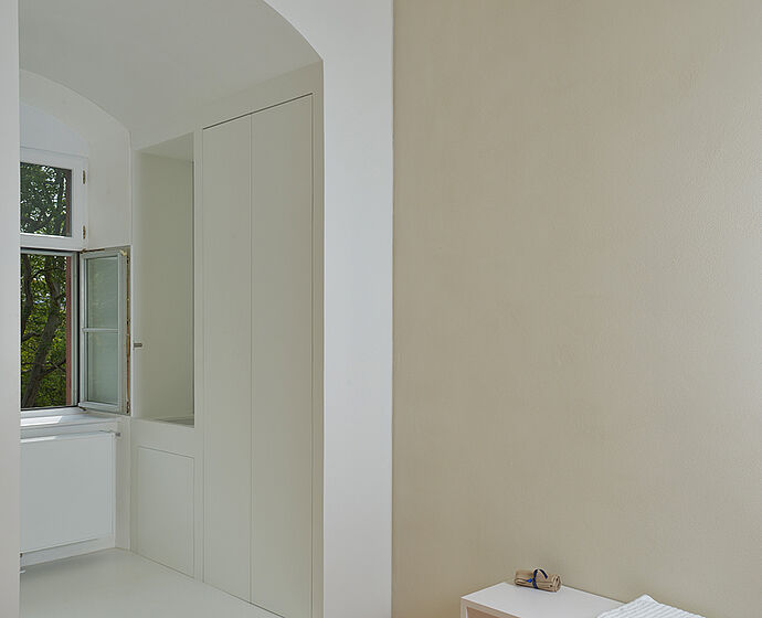 Das Foto zeigt die hintere rechte Ecke des Raumes der doppelten Wand und dem Fenster