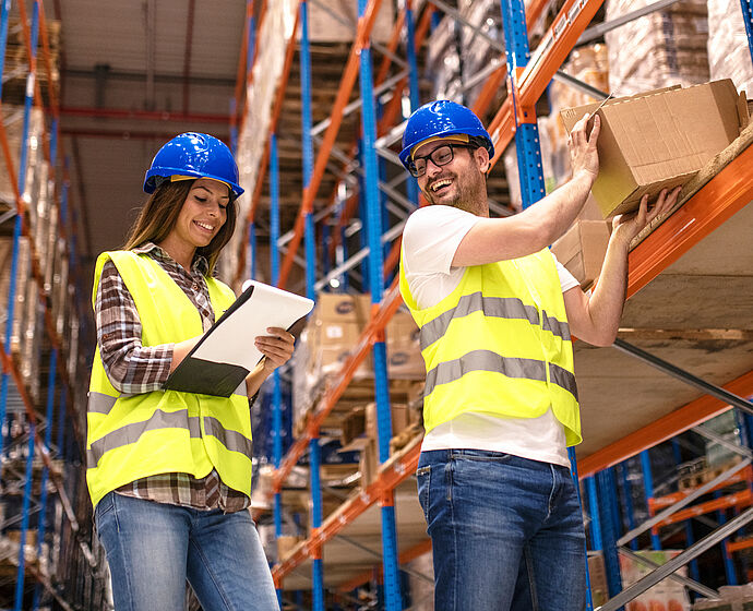 Warehouse Distribution - Zwei junge Menschen arbeiten zusammen in einem Lagerhaus