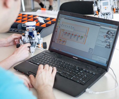 Blick auf einen Laptopbildschirm &uuml;ber die Schulter eines Studierenden