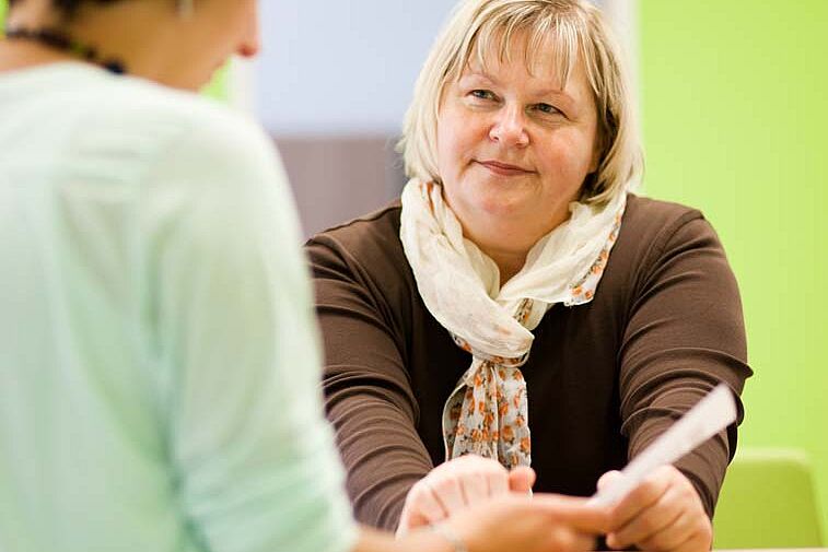Studierender lässt sich an Theke beraten
