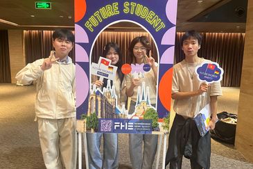 Vier junge Menschen präsentieren sich am FHE-Fotoboard „Future Student“ mit Vietnam- und Deutschlandflaggen bei einer Studienmesse.