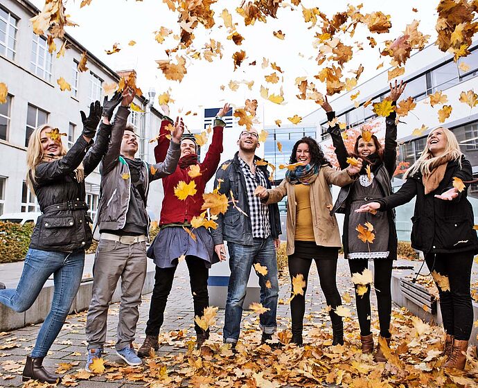 Gruppe Studierende stehen vor der FH im Herbst