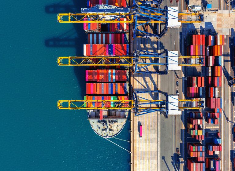 Aerial view of cargo ship and cargo container in harbor.