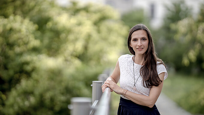 lächelnde Frau vor landschaftlichem Hintergrund