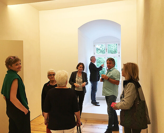 Das Foto zeigt eine Szene aus der Vorstellung des Musterzimmers. Zu sehen sind verschiedene Personen.