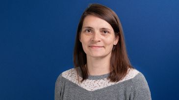Portraitfoto von Juliane Kirchner vor blauem Hintergrund
