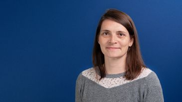 Portraitfoto von Juliane Kirchner vor blauem Hintergrund