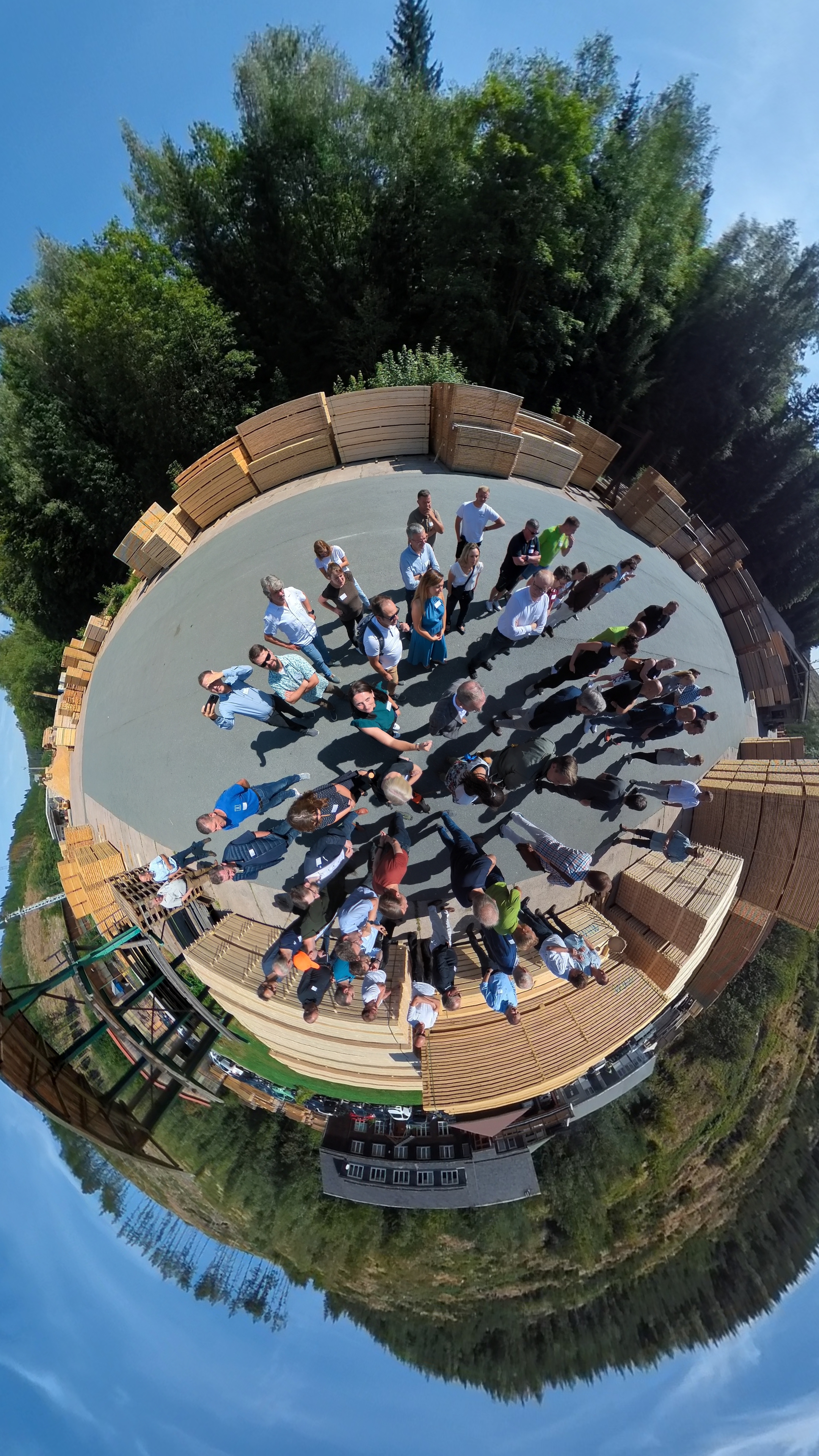 menschen auf einem Platz umgeben von Bäumen