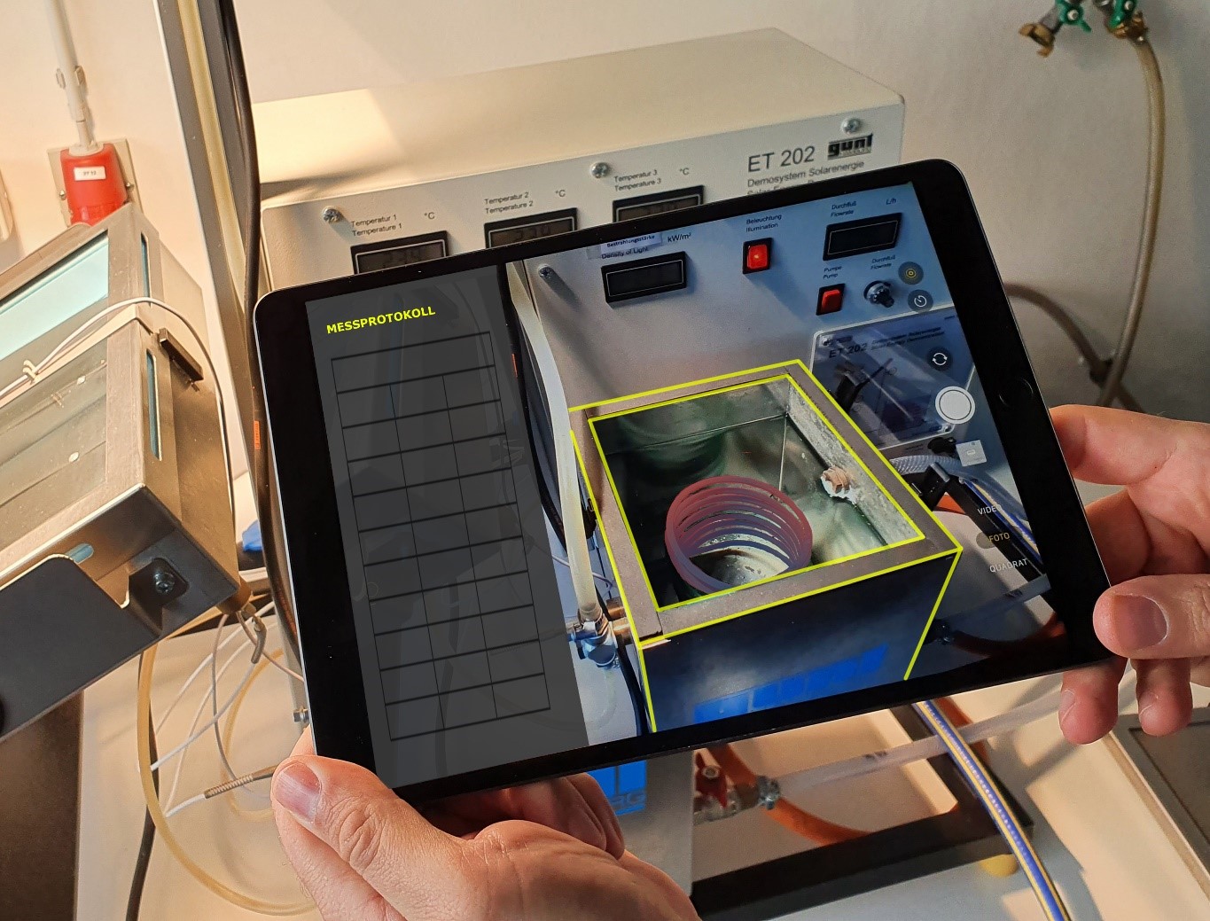 Hände halten ein Tablet, auf welchem die Thermolab-App ausgeführt wird.