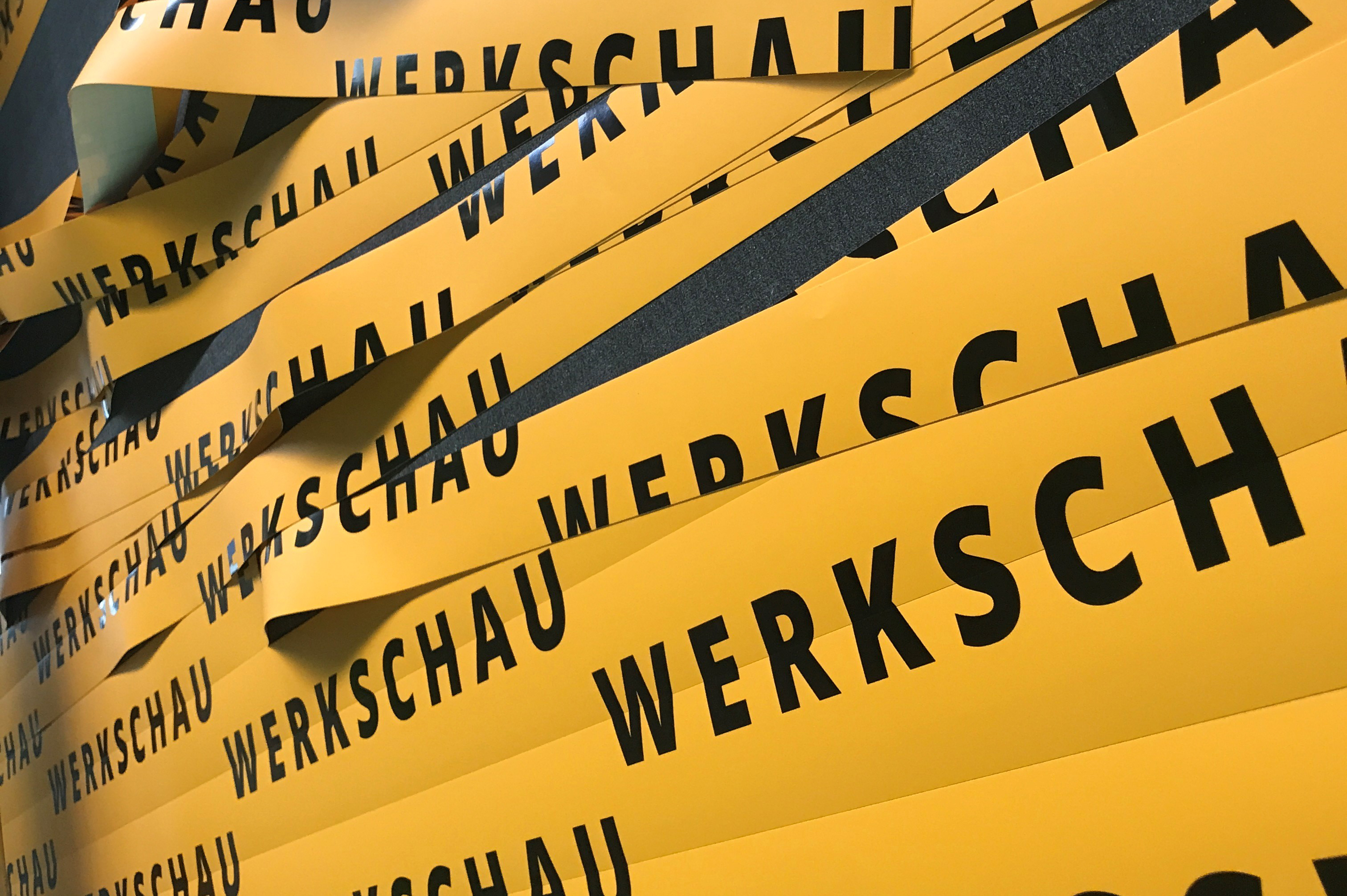 Man sieht geschnittene gelbe Aufkleber mit dem schwarzen Schriftzug "Werkschau"