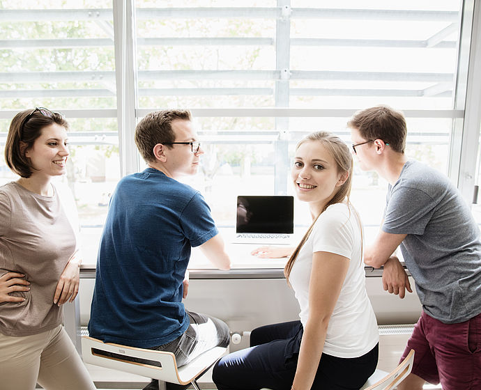 Gruppe Studierende sitzt in der Hochschulbibliothek