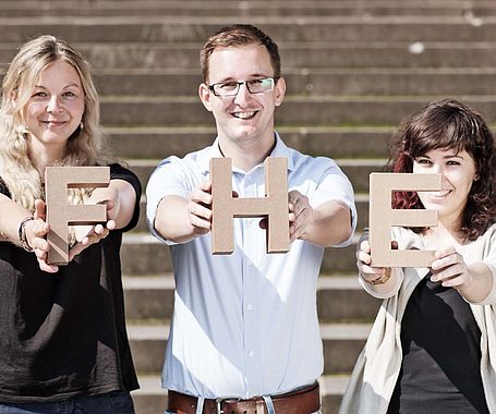 Gruppe Studierende halten FHE-Buchstaben