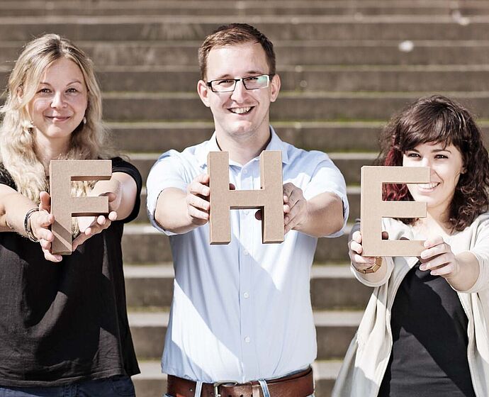 Gruppe Studierende halten FHE-Buchstaben