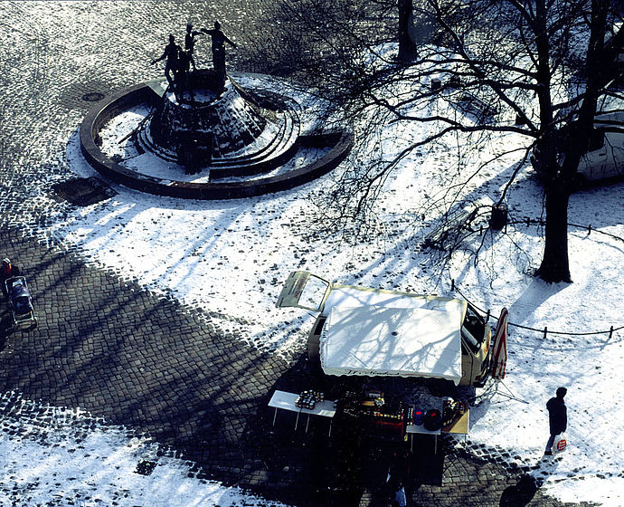 Winterliches Foto des Platzes von oben. Man sieht einen Verkaufsstand.