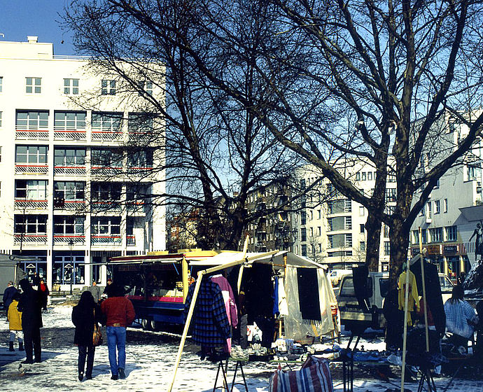 Foto eines kleinen Marktes auf dem Nettelbeckplatz mit dem Studentenheim, dem Wohnblock und dem Solitär im Hintergrund