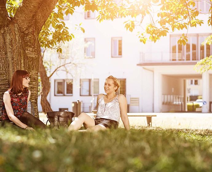 Gruppe Studierende auf dem Campus im Sommer