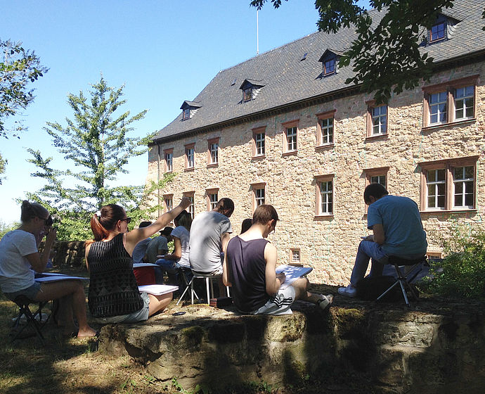 Das Foto zeigt Studierende bei einer Zeichenexkursion auf Schloss Wiehe