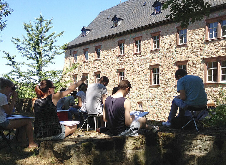Das Foto zeigt Studierende bei einer Zeichenexkursion auf Schloss Wiehe