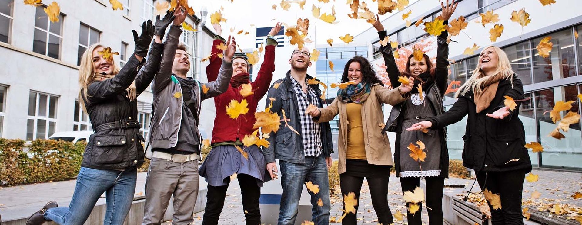 Campusleben Gruppe Studierende stehen vor der FH im Herbst